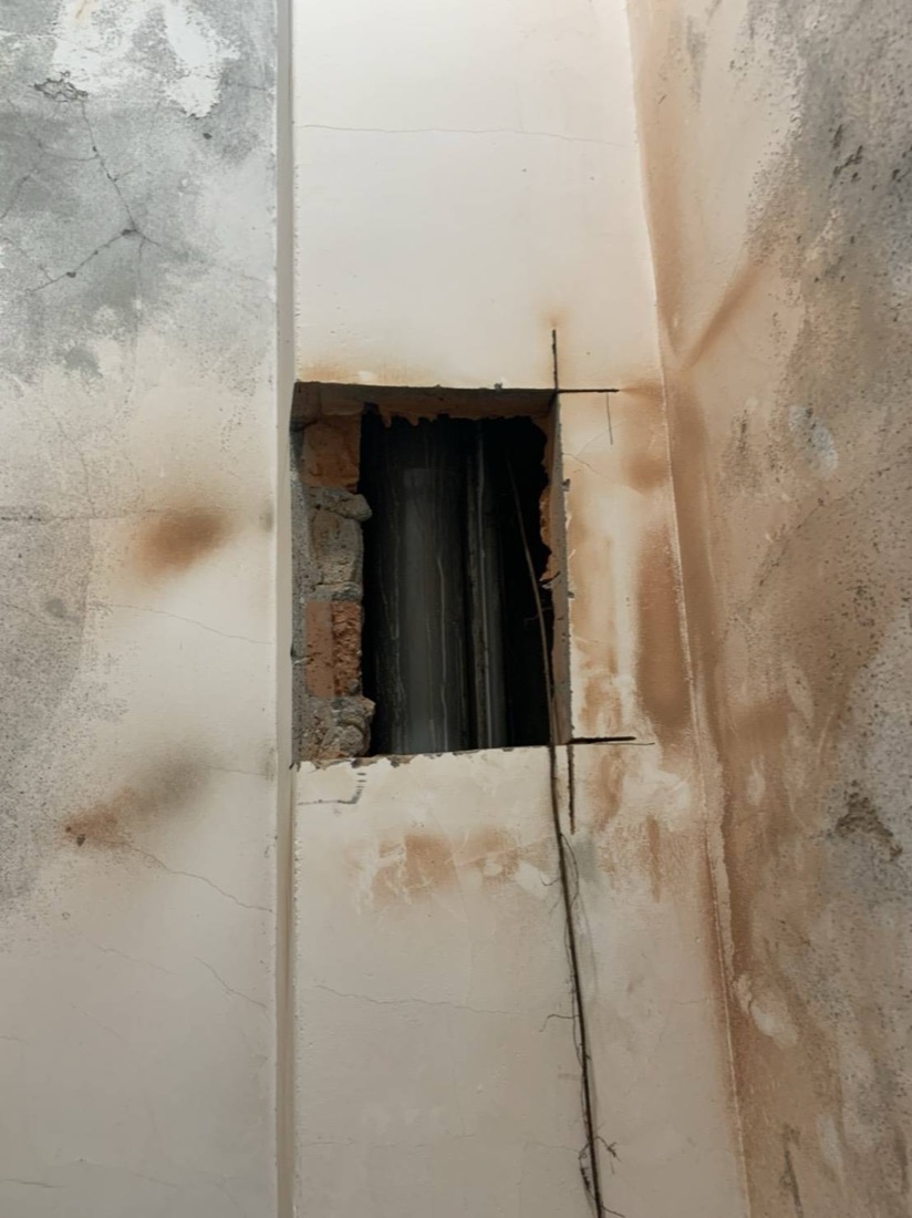 漏水查修：壁面打開後可見漏水後留下的鏽褐色水漬，內部磚牆受潮。